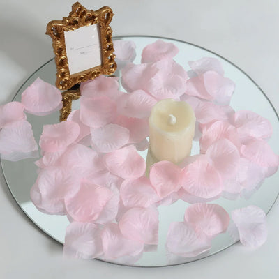 Pink petal table centerpiece with candle and ornate gold photo frame on mirrored tray