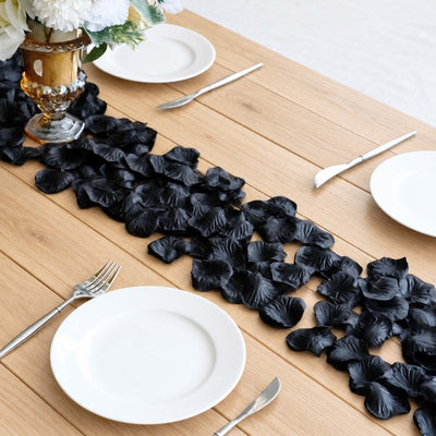 Black floral table runner with white plates and silverware on wooden dining table