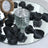 Black chiffon petals around a textured glass votive on a mirrored tray