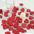 Romantic candle and wine glass on mirrored tray with red rose petals