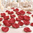 Elegant wedding table with red rose petals, candles, and mirrored centerpiece