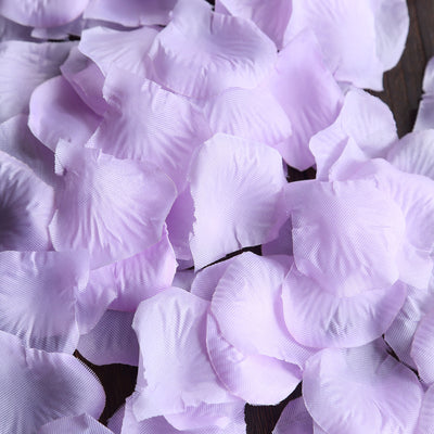 Purple silk flower petals on a wooden surface.