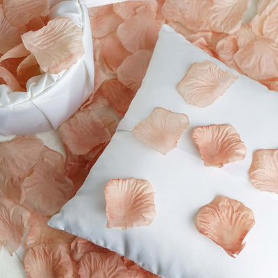 White satin pillows with blush rose petal accents in a romantic floral design