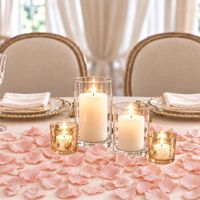Elegant romantic table setting with candles, rose petals, and upholstered chairs