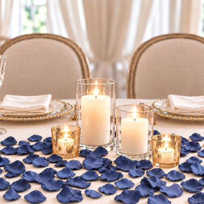 Elegant candlelit dinner table with navy flower petals and gold accents