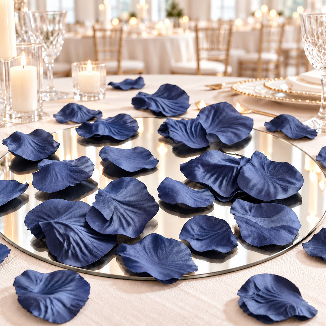 Elegant navy blue flower petals on a mirrored wedding table centerpiece