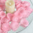 Pink rose petals surrounding a cream candle on a glass plate