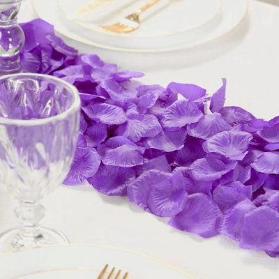 Purple petal table runner with glass goblets on a white table setting