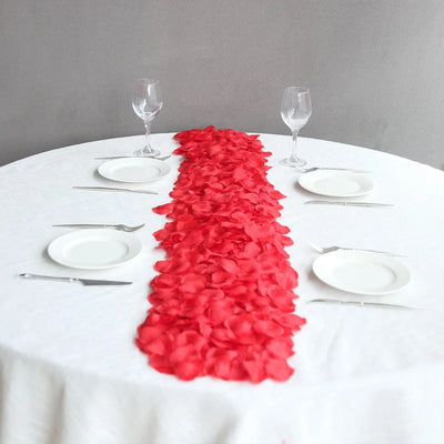 Elegant romantic dining table with red rose petals and place settings