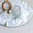 Elegant white rose centerpiece with mirrored tray, glass vase, and gold frame
