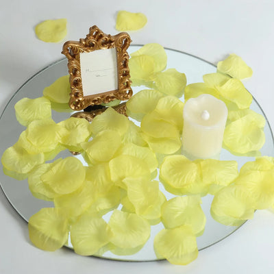 Yellow flower petals on mirrored tray with ornate frame and candle centerpiece