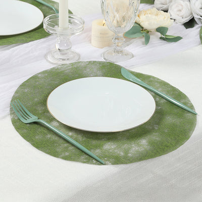 Green round placemat with a white plate and mint cutlery on a dining table setting.