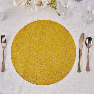 Gold glitter round placemat with silver cutlery on a textured tablecloth.