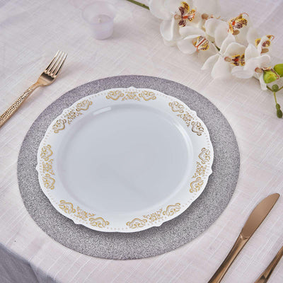Elegant white plate with gold trim on a textured grey placemat.