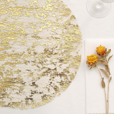 Elegant gold and white table placemat with dried flower decor.