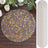 Gold floral design table runner on wooden surface.