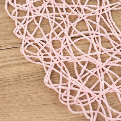 Pink woven string on a wooden surface.
