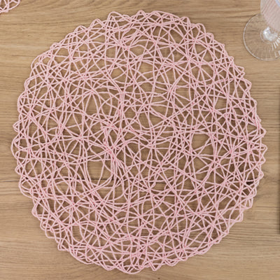 Pink woven table placemat in a circular design.