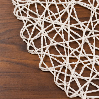 Textured white string mat on a wooden surface.