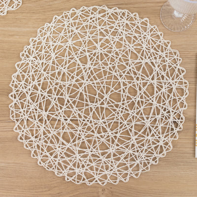 White woven round placemat on a wooden table.