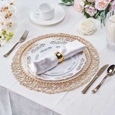 Elegant white plate with golden accents and a napkin on a decorative table setting.