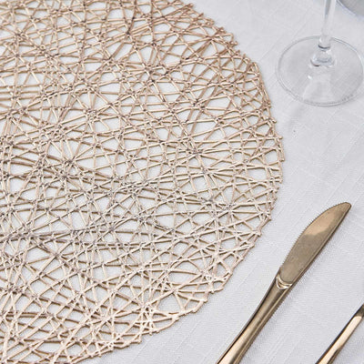 Elegant round woven placemat on a textured tablecloth with gold cutlery.