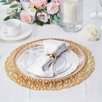 Elegant dining setup with decorative plates and napkin on a gold lace charger.