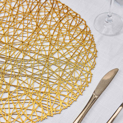 Gold woven placemat on a textured table setting with cutlery.