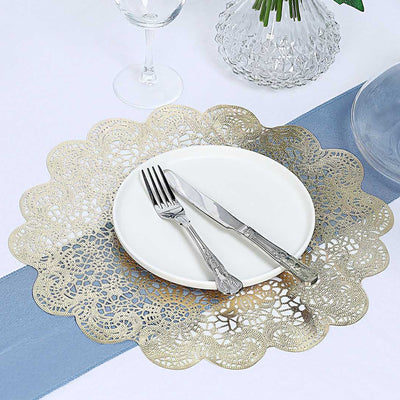 Gold lace table runner with white plate and silver cutlery on a blue table setting.