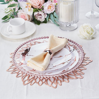 Elegant dinner plate with rose gold accents and a napkin on a decorative placemat.