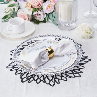 Elegant dinner table setting with a decorative napkin and floral centerpiece.