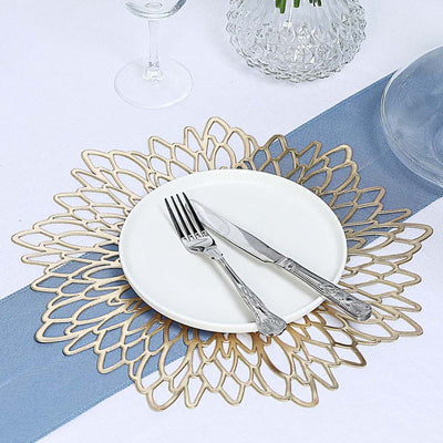 Elegant gold floral placemat with white plate and silver cutlery on a table setting.
