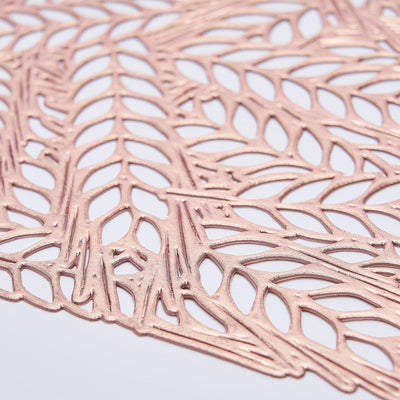 Rose gold lace paper cutout detail on white background.