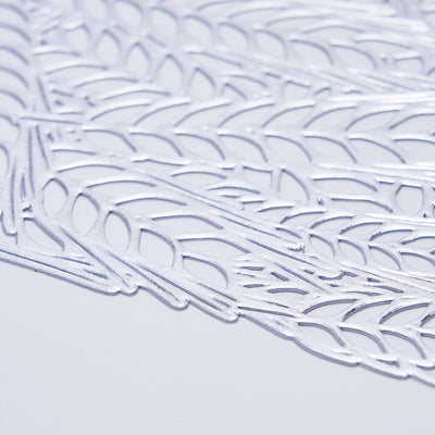 Intricate silver lace design on a plain backdrop.