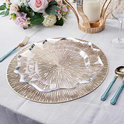 Elegant clear plate atop a decorative charger on a beautifully set dining table.