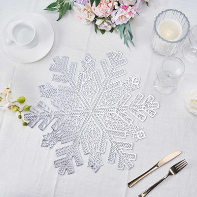 Silver lace snowflake placemat on a table setting with floral decor.
