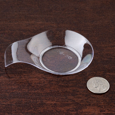 Clear glass dish next to a quarter for size reference.