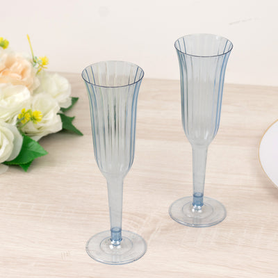 Blue fluted champagne glasses on a wooden surface.