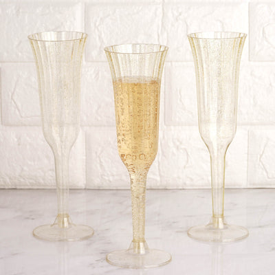 Elegant gold champagne flutes with bubbles on a marble surface.