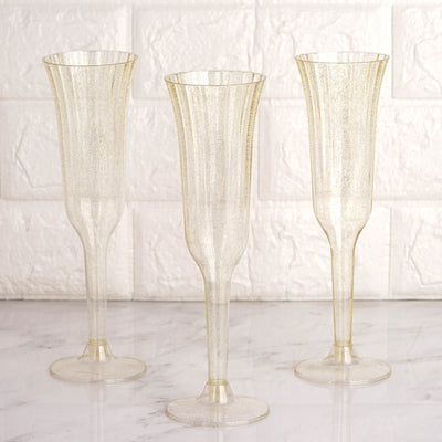 Gold-speckled champagne flutes on a marble surface