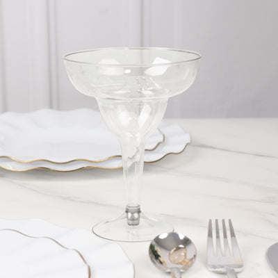 Clear glass dessert cup on a marble table with elegant plates and cutlery.