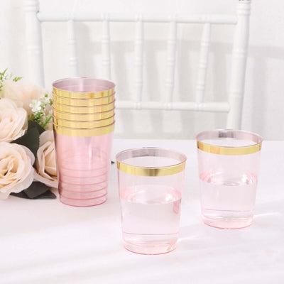 Pink and gold plastic cups stacked with two glasses filled with water.