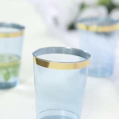 Blue plastic cups with gold bands on a soft, blurred background.