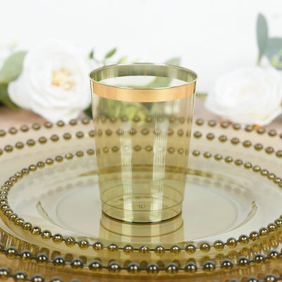 Gold-trimmed clear plastic cup on decorative plate with floral backdrop.