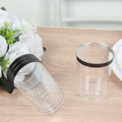 Clear plastic cups with black lids on a wooden table.