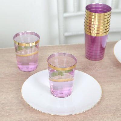 Pink and gold glasses on a table with a white plate.