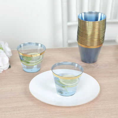 Blue and gold glassware set with drinks and a plate on a wooden table.