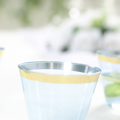 Clear glass with gold rim, filled with water and mint leaves.