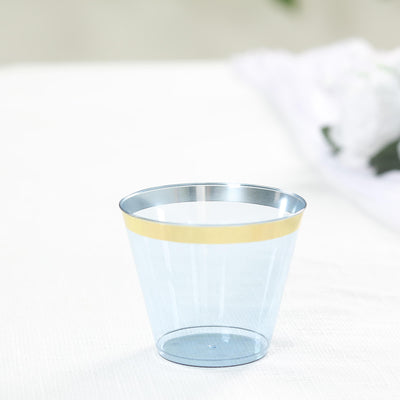 Transparent cup with a gold band on a plain background