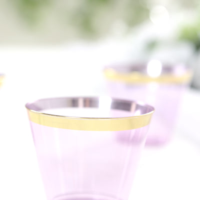 Purple plastic cups with gold rims on a blurred background.